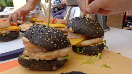 Mit Sepia gefärbter Burger gefüllt mit Garnelen und zartem Hähnchenfleisch